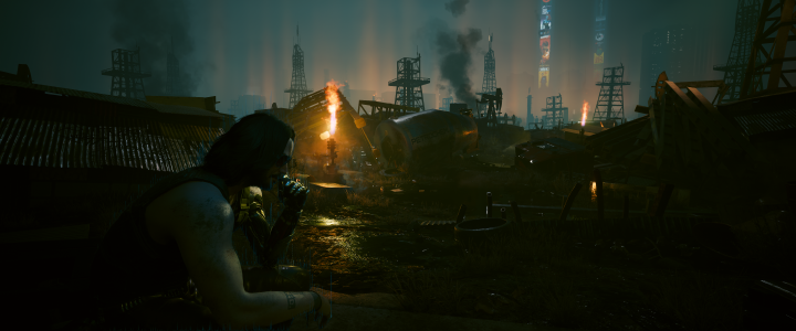 Game screenshot showing Johnny silverhand smoking on a dark scrappyard, with Night City in the far background